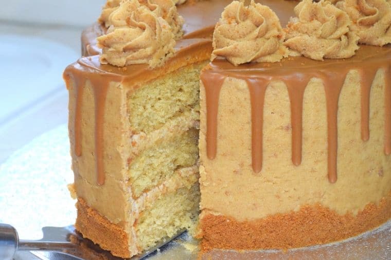 Close up of a Biscoff drip cake with a slice partially removed.