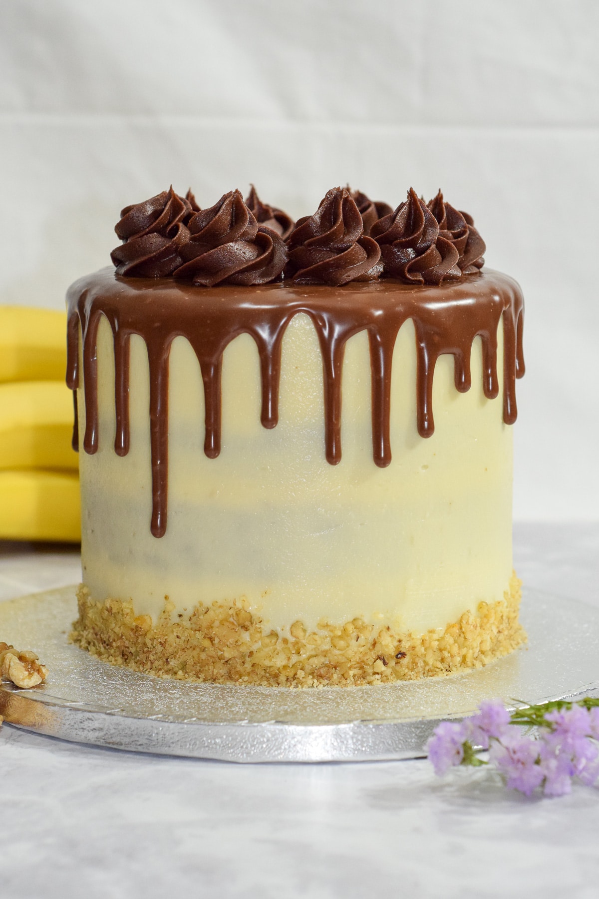 Banana walnut cake with vanilla cream cheese frosting and a milk chocolate ganache drip - whole cake