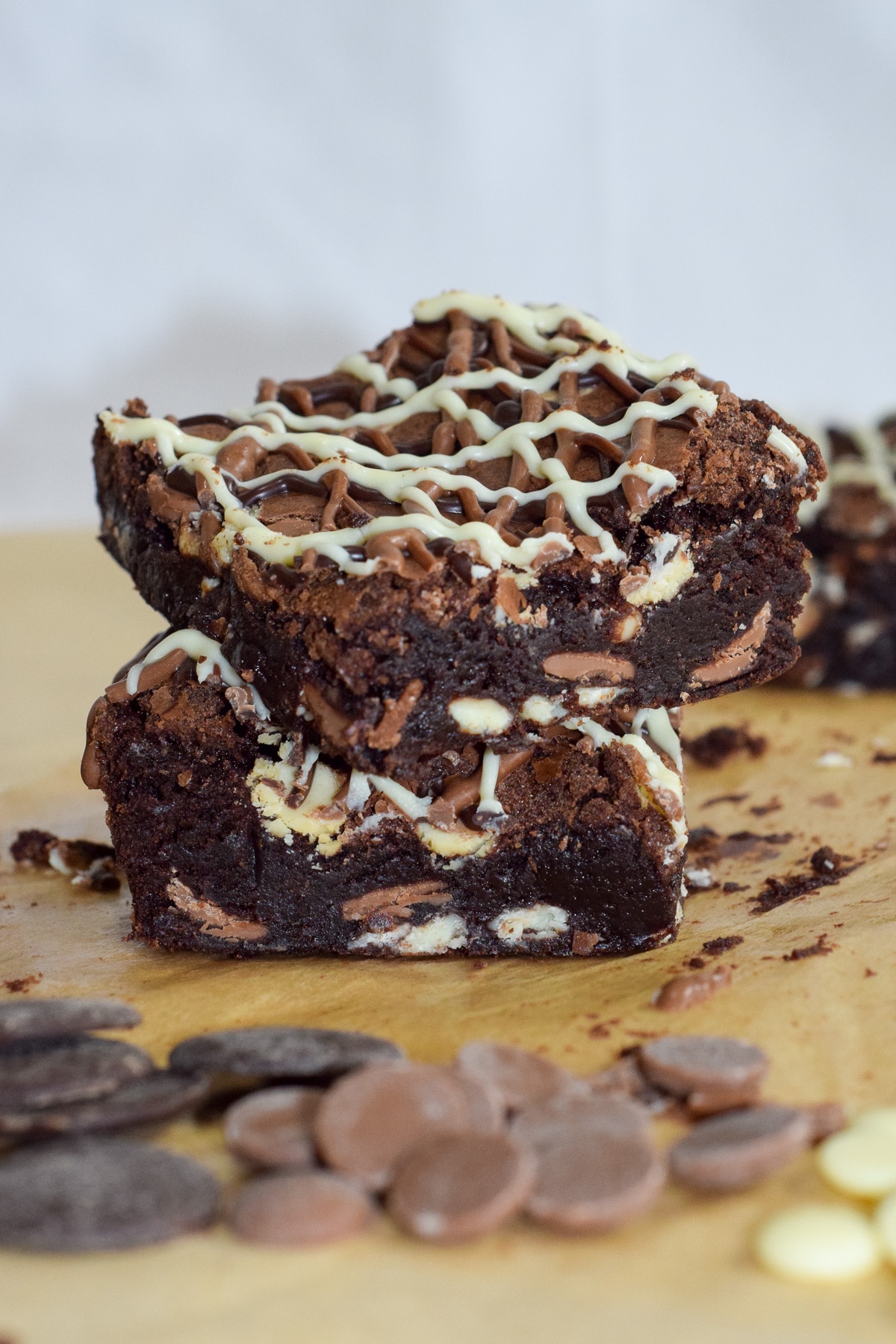 Fudgy triple chocolate brownies with triple chocolate drizzle stacked
