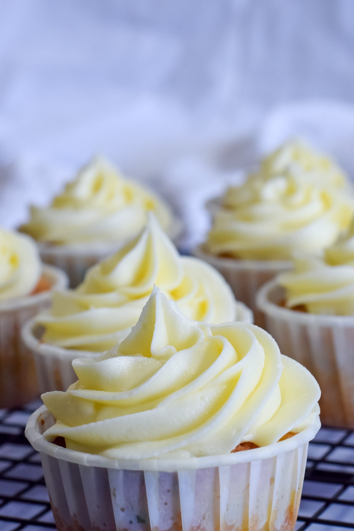 Easy vanilla american buttercream frosting recipe piped onto cupcakes