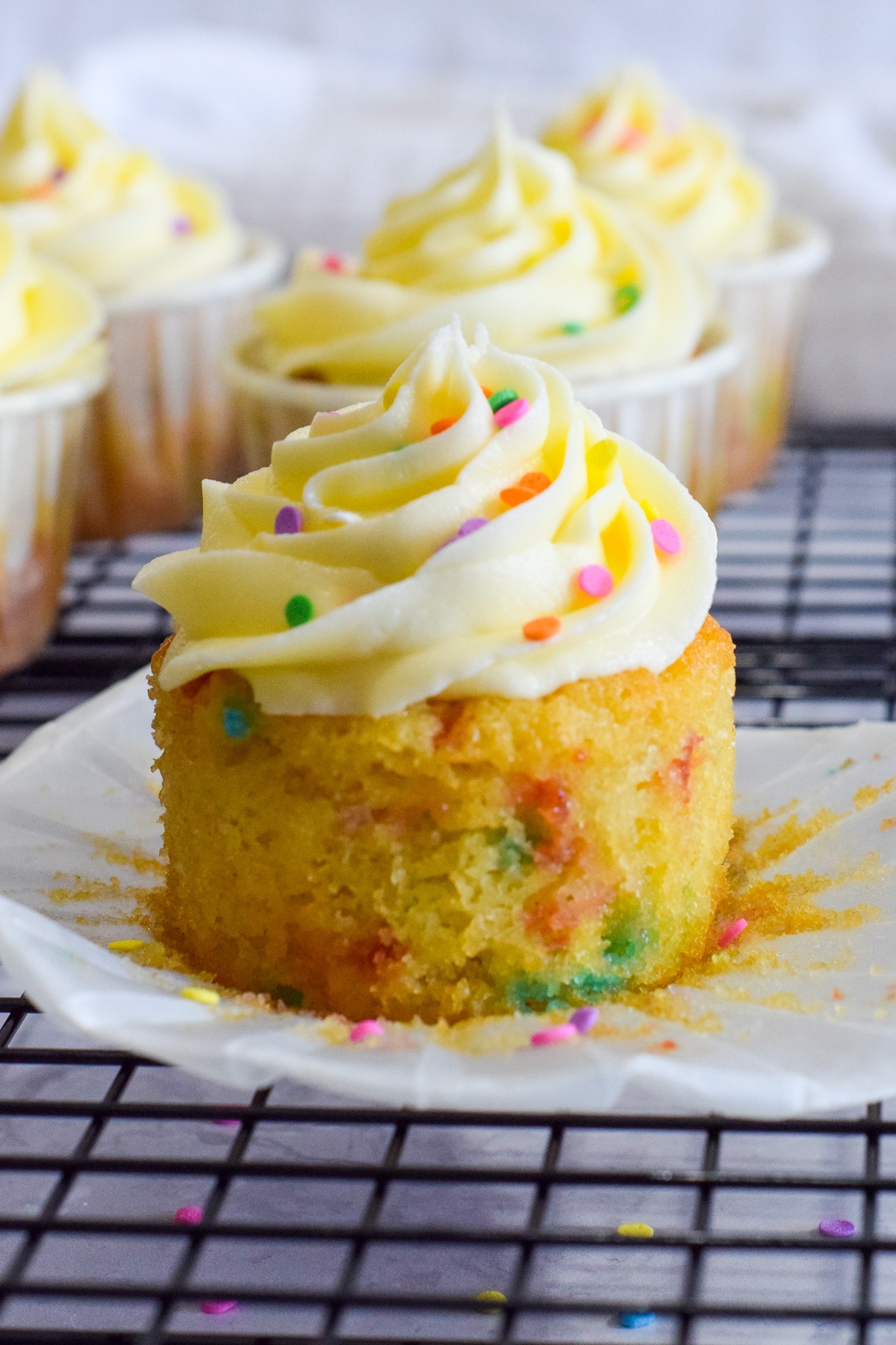 vanilla funfetti cupcakes with confetti sprinkles inside and on top of vanilla buttercream