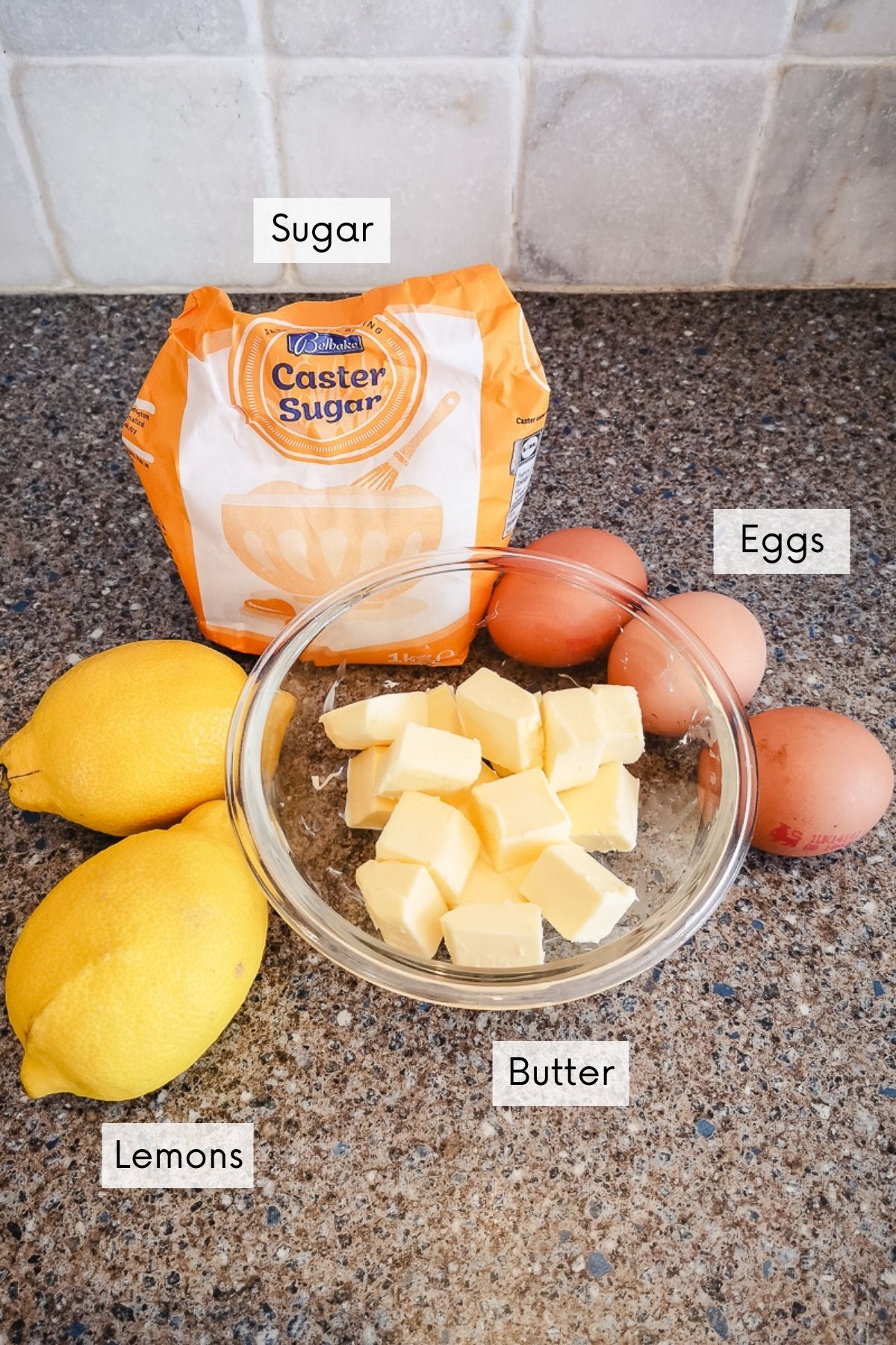 lemon curd filling ingredients showing sugar, lemons, eggs and butter