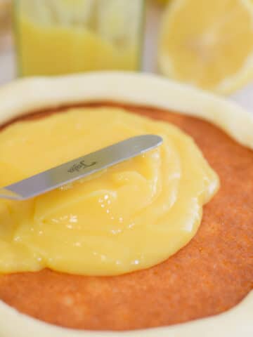 lemon curd cake filling spread onto a cake layer within a frosting dam