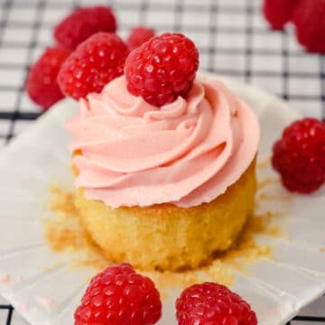open vanilla raspberry cupcake with a fresh raspberry on top