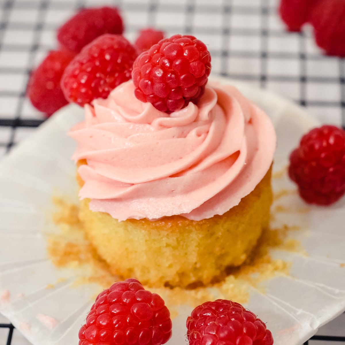 open vanilla raspberry cupcake with a fresh raspberry on top