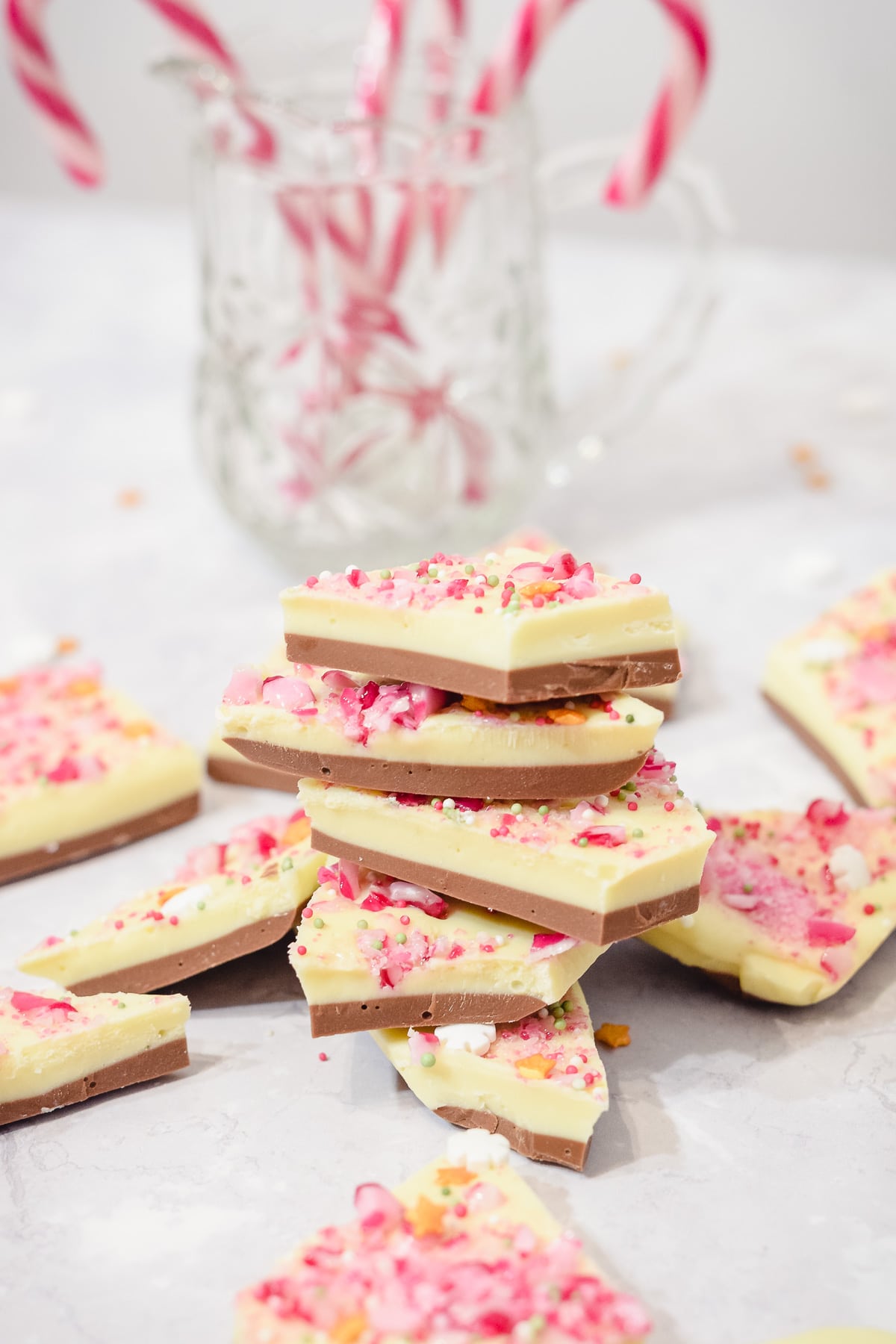 White chocolate peppermint Christmas bark pieces stacked with candy canes
