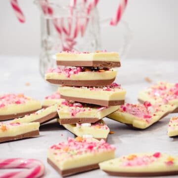 White chocolate peppermint Christmas bark pieces stacked with candy canes