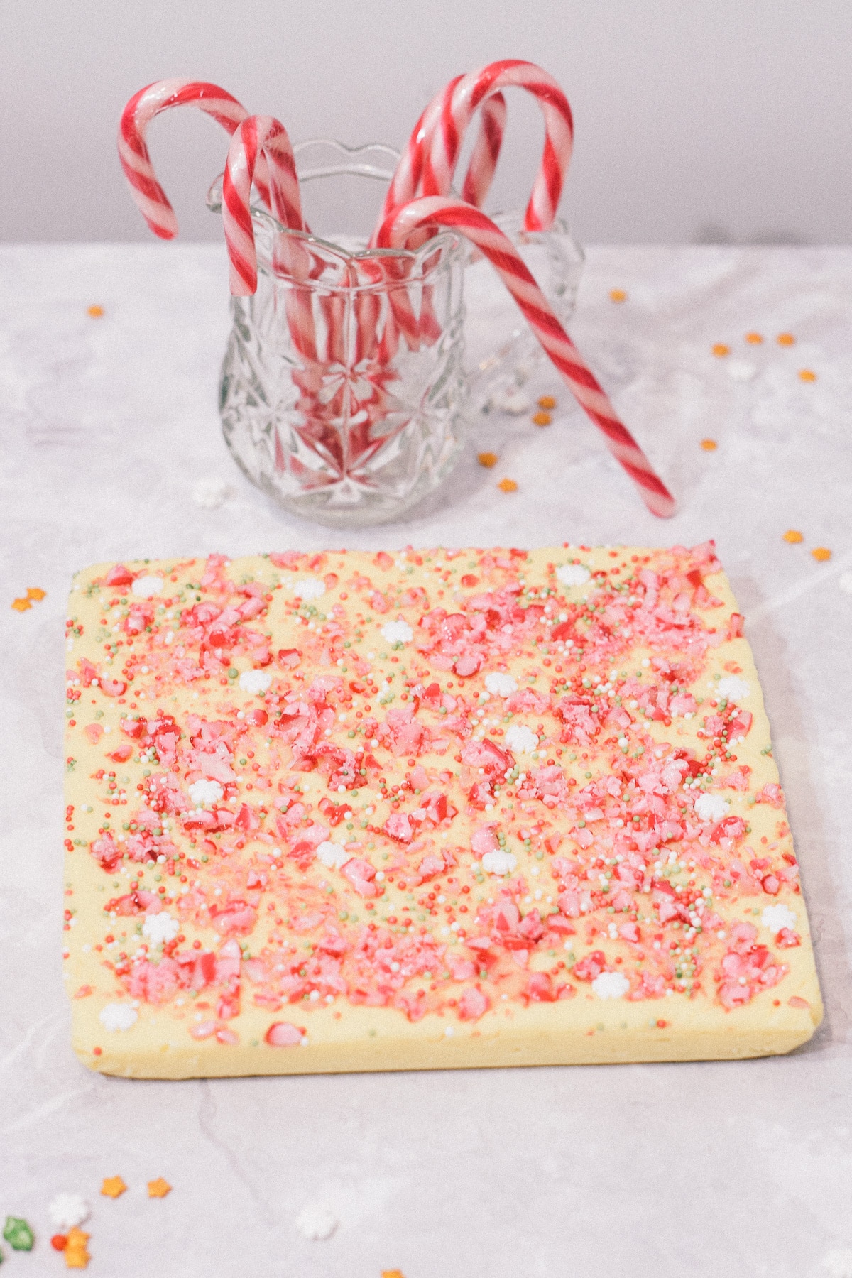 White Chocolate Peppermint Christmas fudge slab whole with candy canes in jar
