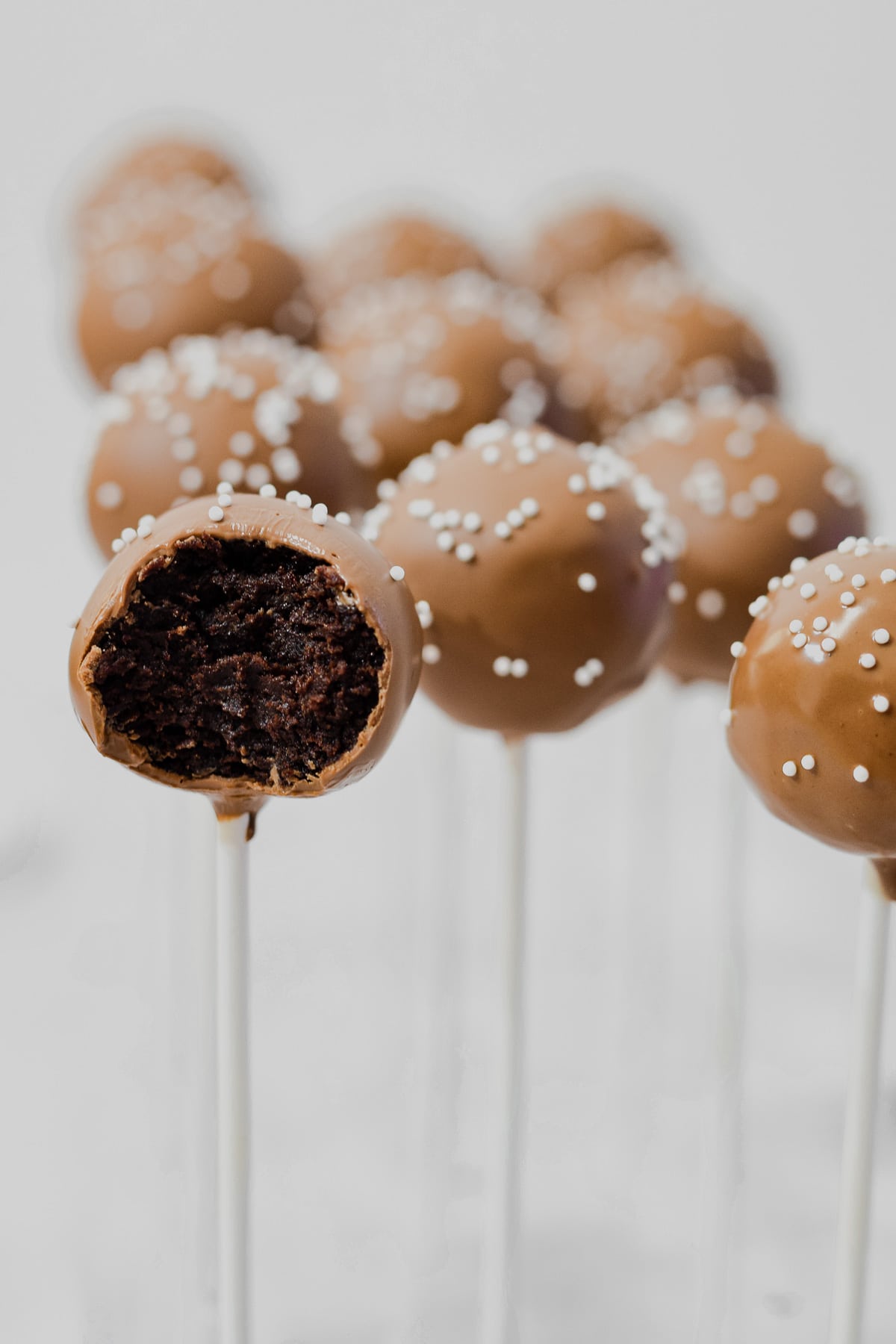 starbucks copycat chocolate coated chocolate cake pops with one bitten in half to show chocolate cake ball middle