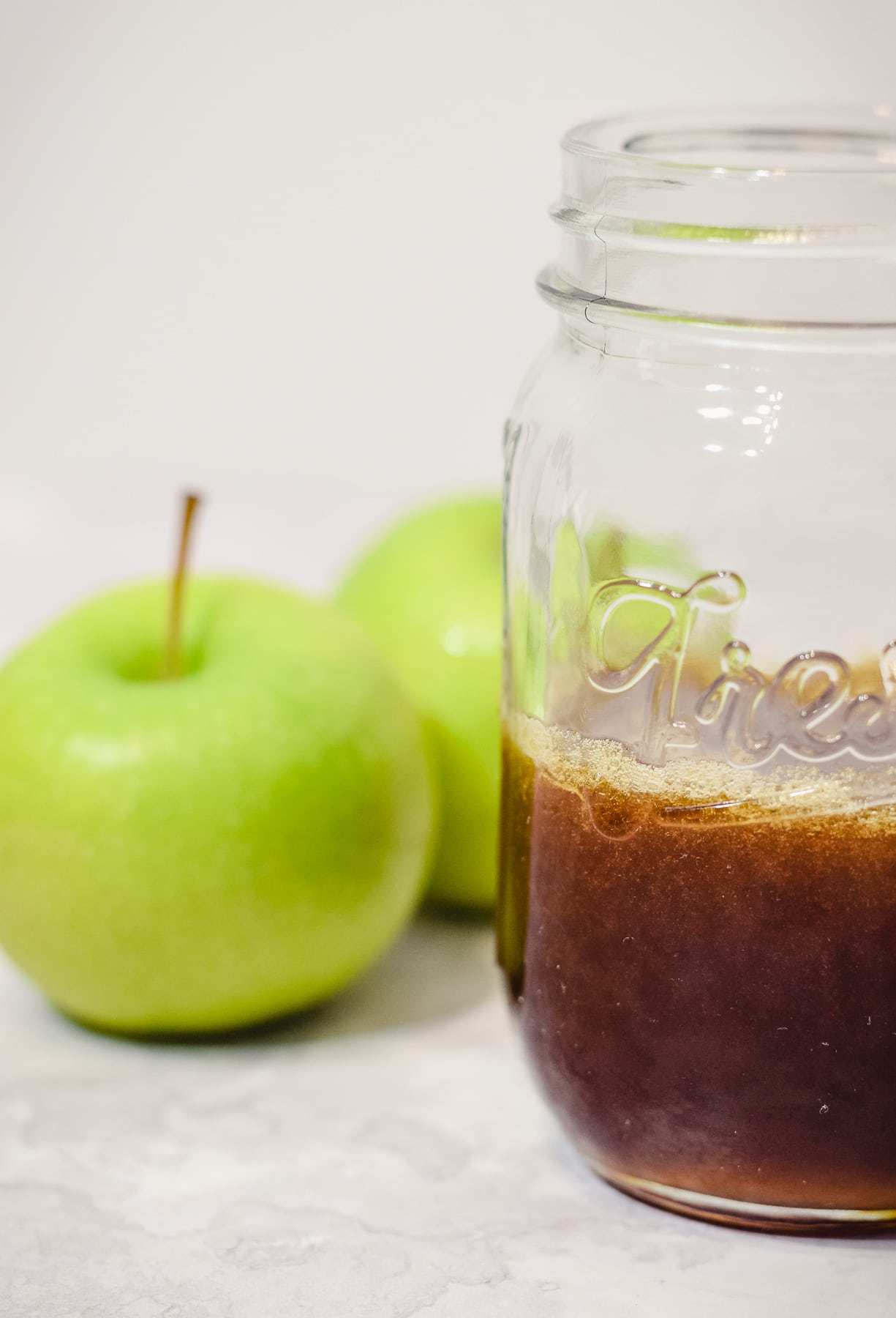 apple syrup in mason jar with fresh apples