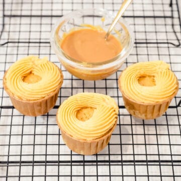 caramel buttercream frosting swirls on cupcakes with a bowl of store-bought caramel behind