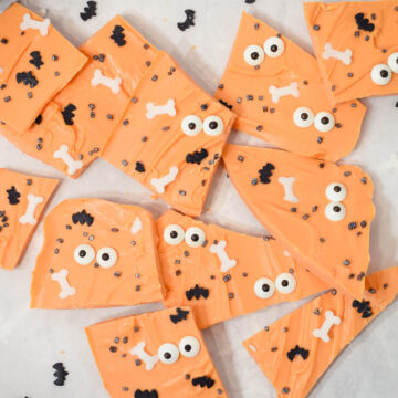 cute halloween orange coloured bark with candy eyes and Halloween sprinkles broken into pieces.