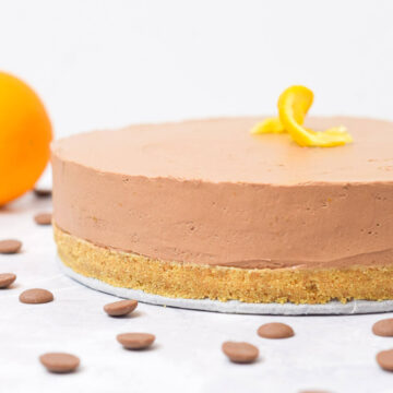 chocolate orange cheesecake with graham cracker crust topped with a twisted orange slice.