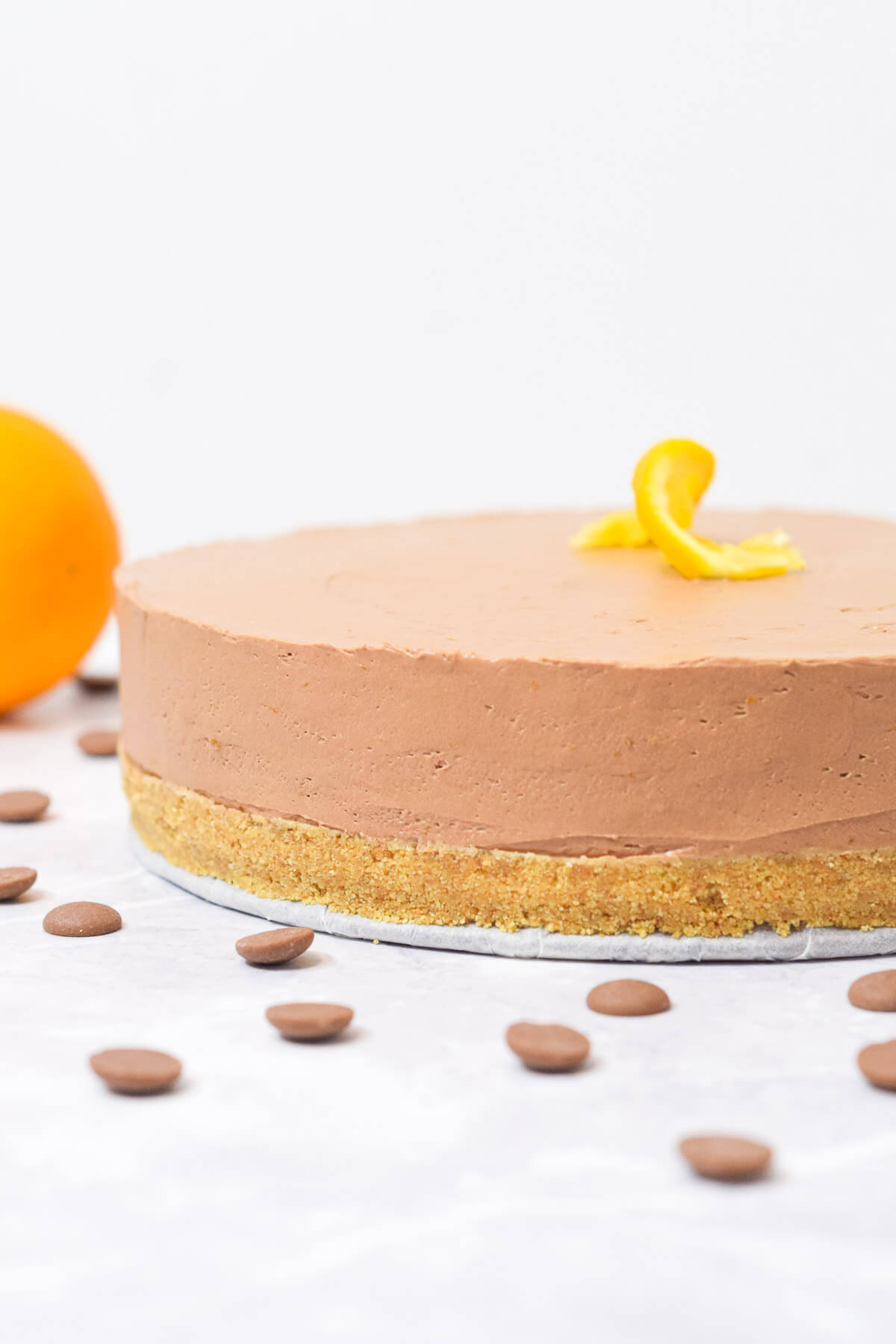 chocolate orange cheesecake with graham cracker crust topped with a twisted orange.