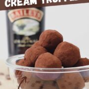 baileys irish cream chocolate truffles covered in cocoa powder in a bowl with a bottle of baileys irish cream.