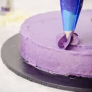 purple ube buttercream frosting in a piping bag on a cake
