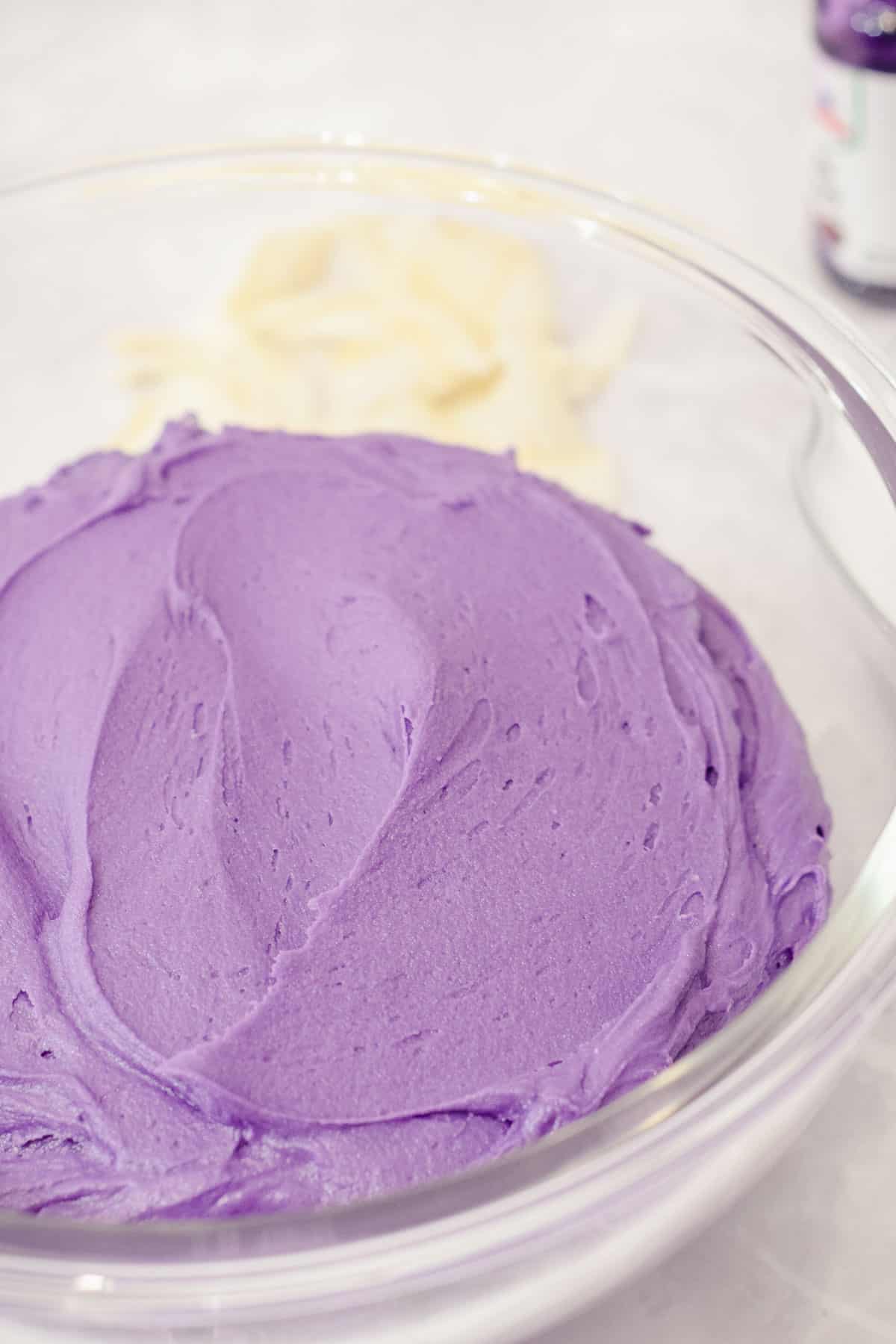 purple yam buttercream frosting in a bowl with coconut and ube extract