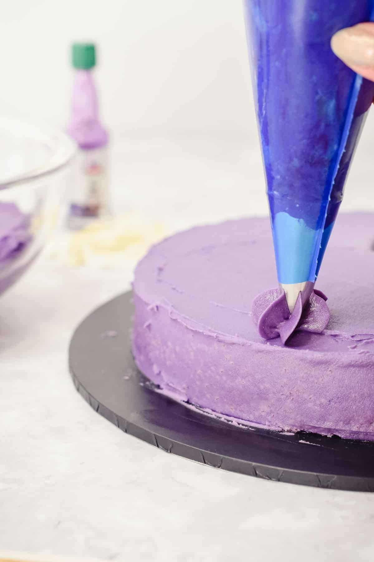 purple ube buttercream frosting in a piping bag on a cake