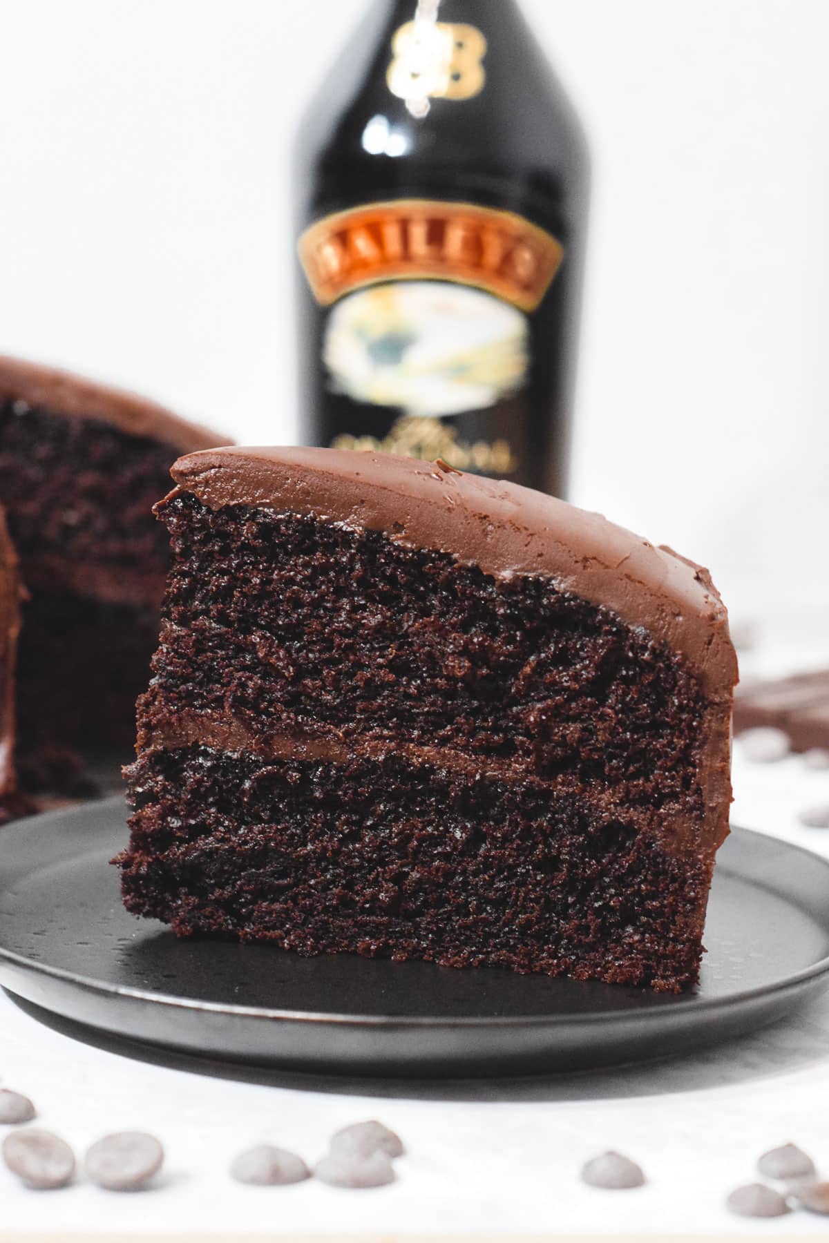 slice of baileys chocolate layer cake with baileys chocolate ganache frosting and filling.