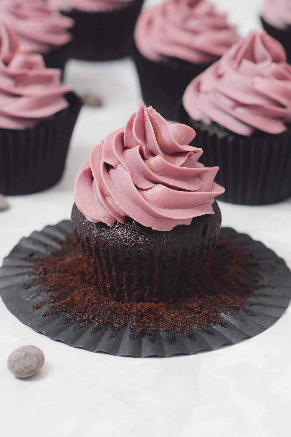 rich chocolate cupcakes with piped pink buttercream frosting swirl topping.