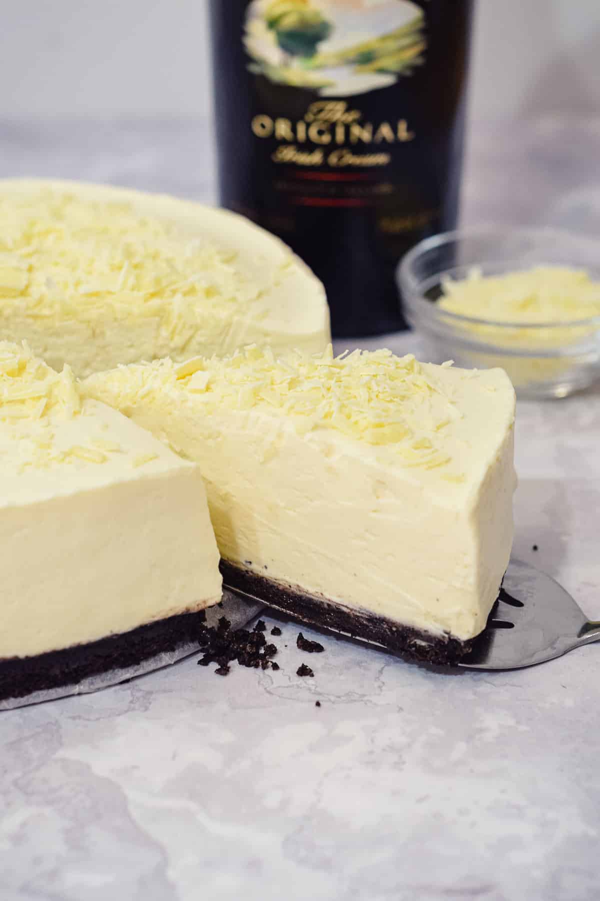 baileys irish cream white chocolate cheesecake with an oreo base and white chocolate shavings.
