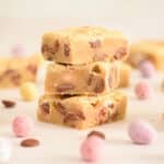 Stack of mini egg blondies squares with cadbury's mini eggs and chocolate chips.