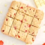 strawberry blondies with white chocolate chips and strawberries in squares.