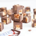 snickers fudge candy bar squares stacked with snickers bar.