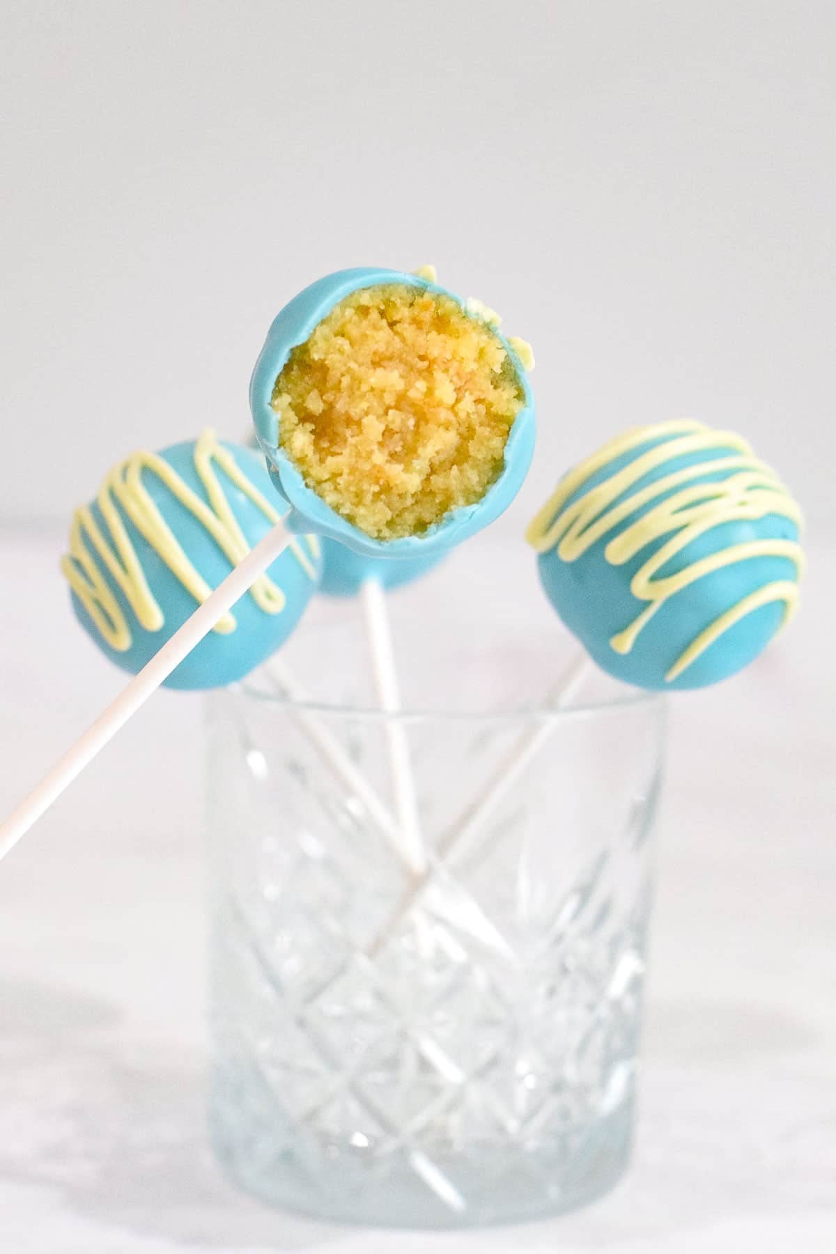 blue cake pops on sticks showing vanilla cake pop filling.