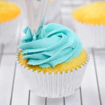 vanilla blue buttercream frosting piped onto a cupcake.
