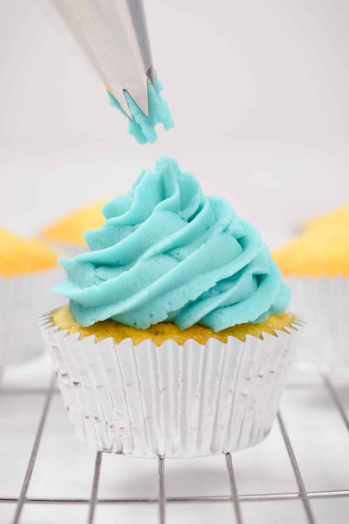 vanilla blue buttercream frosting piped onto a cupcake.