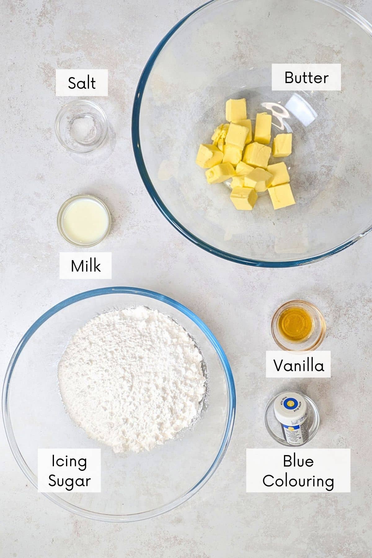 vanilla blue buttercream frosting recipe ingredients in bowls with labels.